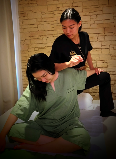 Terapeuta de masaje tailandés con técnica de torsión de cliente sentada