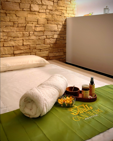 Spa con toalla blanca, pétalos de flores y productos de cuidado personal en un ambiente relajante.