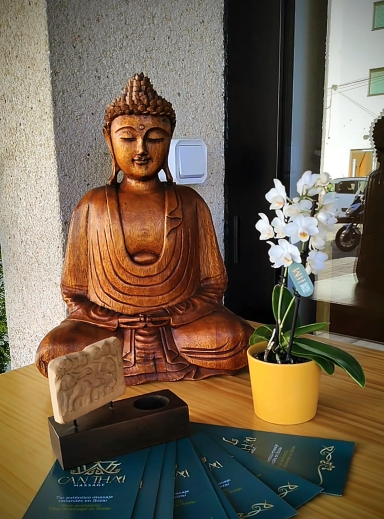 Buda en madera, orquídea blanca en la recepción del centro Can Thai Massage Ibiza